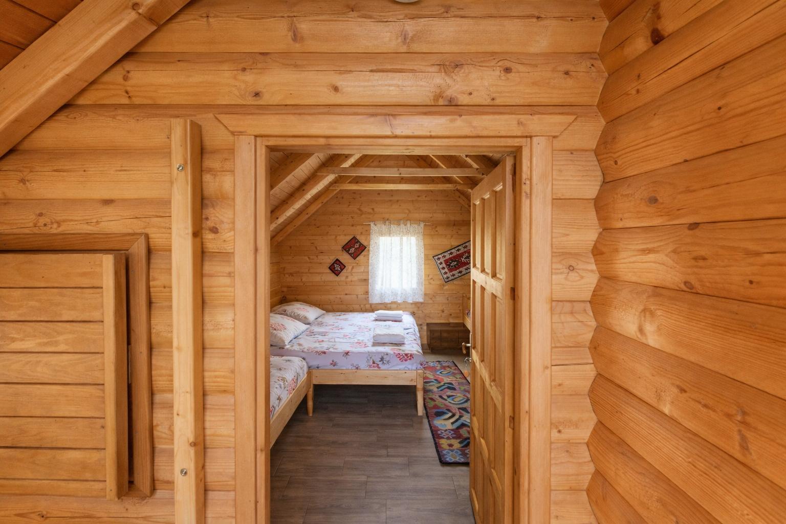 Unutrašnjost drvene brvnare u Etno selu Vidikovac sa bračnim i dodatnim ležajem