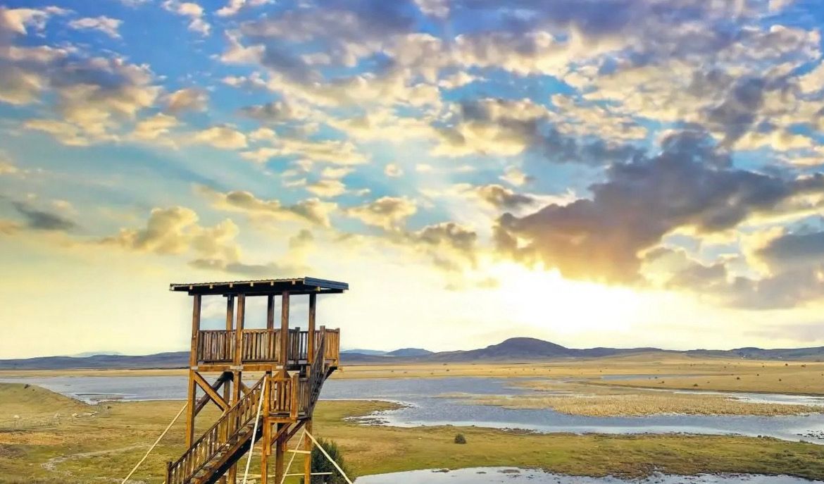 Pešterska visoravan u Srbiji, pogled sa drvenog vidikovca na jezero i prostrane livade u zlatnom zalasku sunca