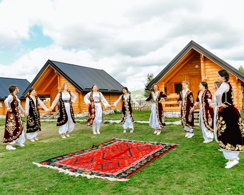 Folklorna grupa u narodnim nošnjama ispred brvnara Etno sela Vidikovac kod Uvca